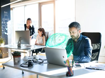 Three business people in the workplace. Two women and man sitting in the office working together.